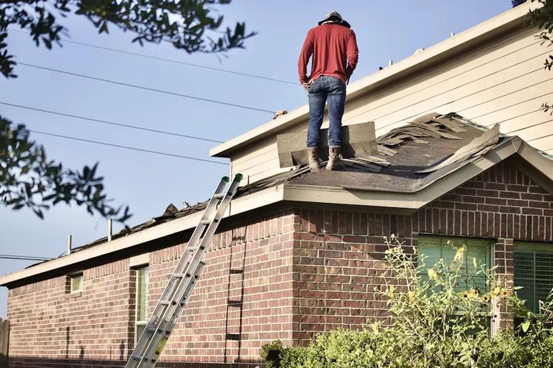 Professional roofer working on a residential roof in Beckett